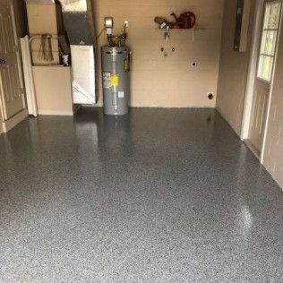 A garage with a gray floor and a water heater.