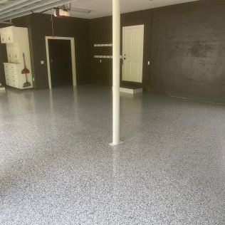 A garage with a gray floor and black walls.