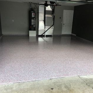 A garage with a purple floor and a black door.