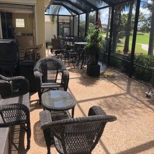 A screened in porch with wicker chairs and tables