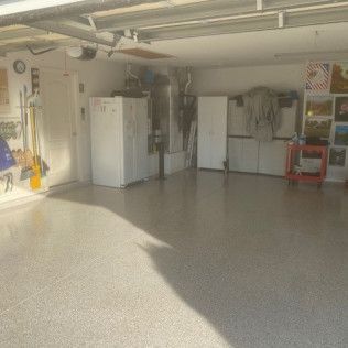 A large garage with a lot of storage space and a concrete floor.