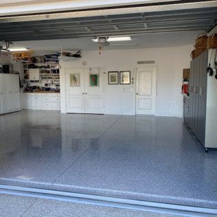 A garage with a garage door open and a gray floor.