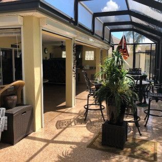 A patio area with tables chairs and a potted plant
