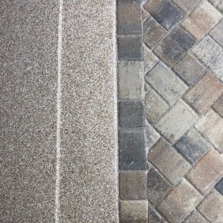 A close up of a carpet and a brick floor.