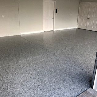 A garage with a gray floor and white doors.
