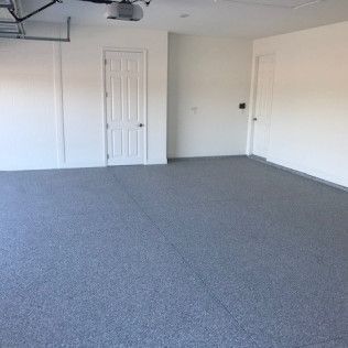 An empty garage with a gray floor and white walls.