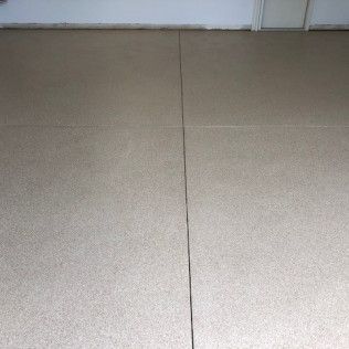 A close up of a tiled floor in a room with a door in the background.