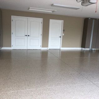 A garage with a concrete floor and white doors.