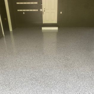 A garage with a gray floor and a white door.