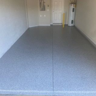 A garage with a gray floor and a water heater.