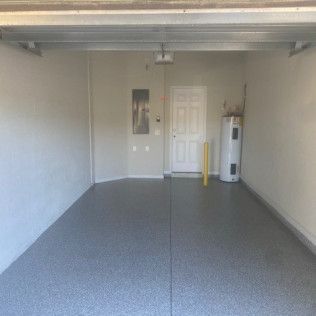 An empty garage with a water heater and a door.