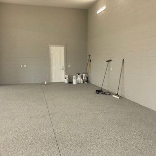 A large empty garage with a concrete floor and a door.