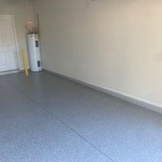 A garage with a water heater and a gray floor.
