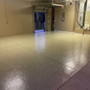 A garage with a shiny floor and a garage door open.