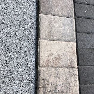 A close up of a concrete surface next to a brick walkway.