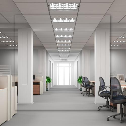 A long hallway in an office with cubicles and chairs