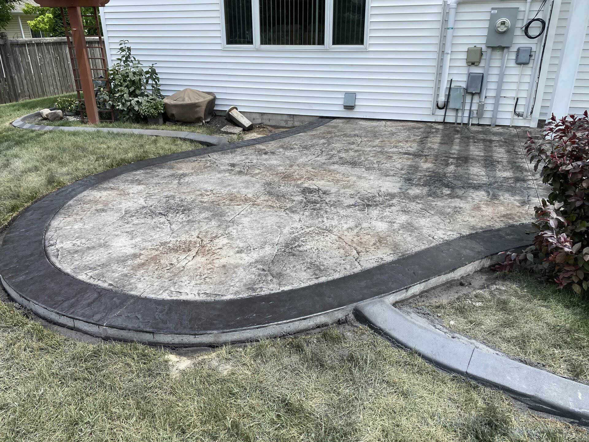 A patio is being built in the backyard of a house.