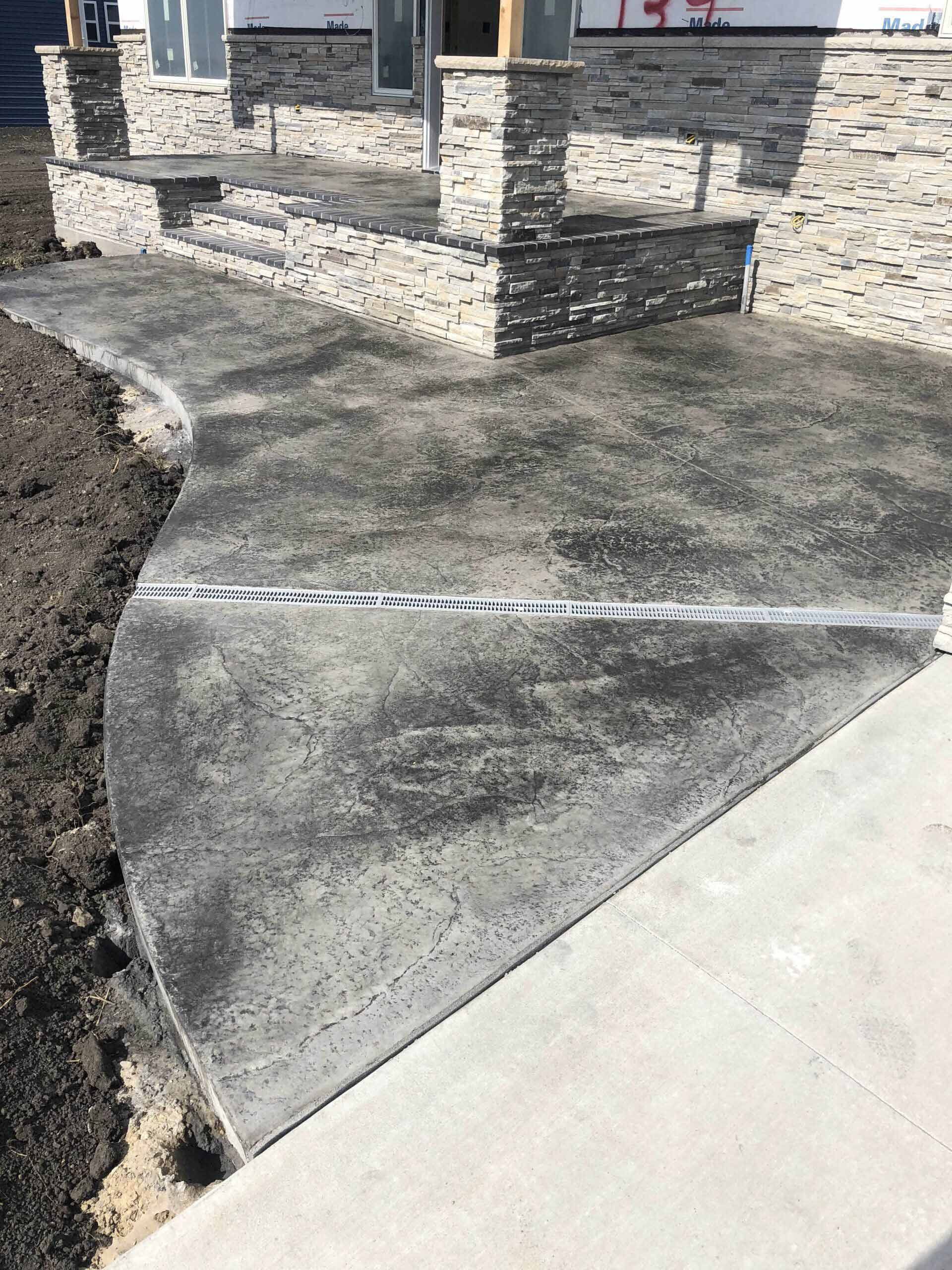 A concrete walkway is being built in front of a house.
