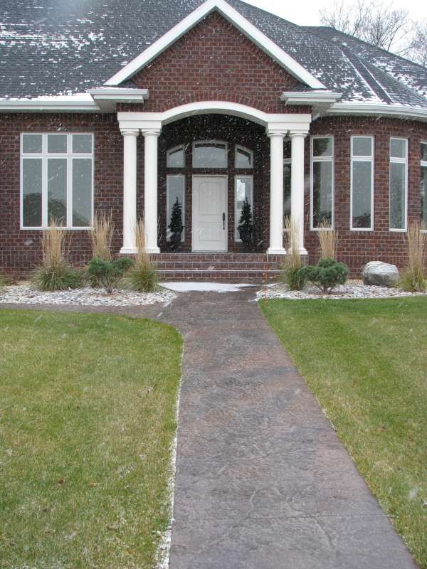 A brick house with a walkway leading to the front door
