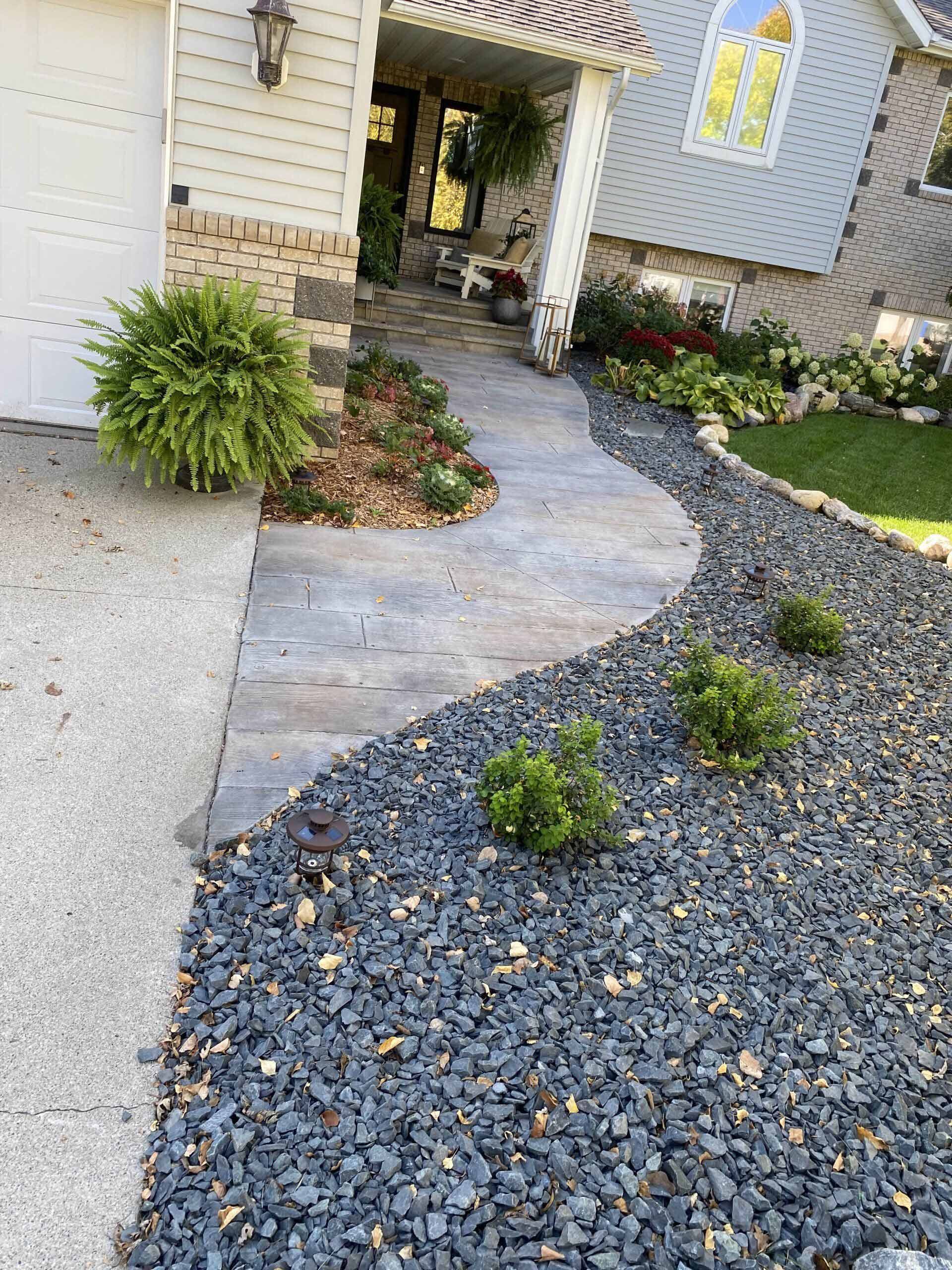 There is a walkway leading to the front of the house.