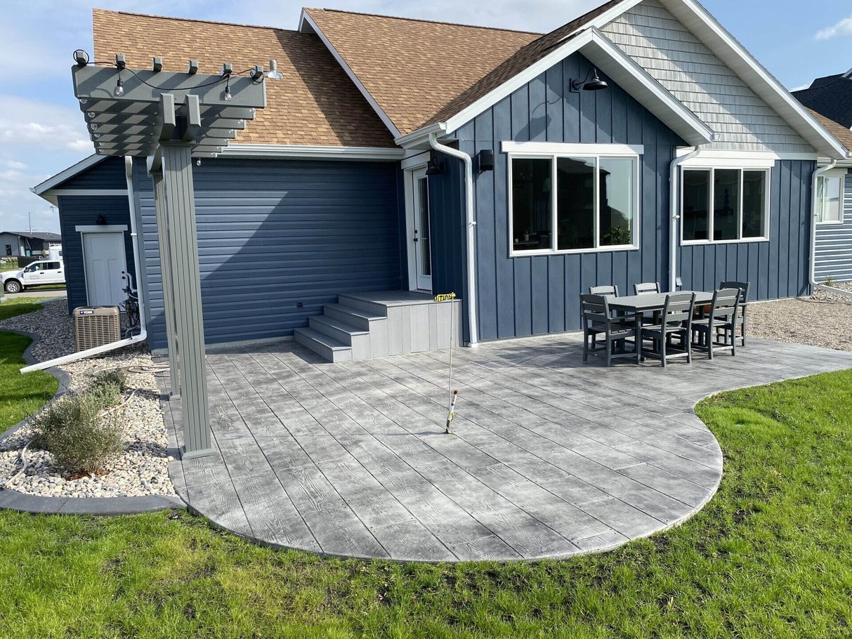 A blue house with a patio and a pergola in front of it
