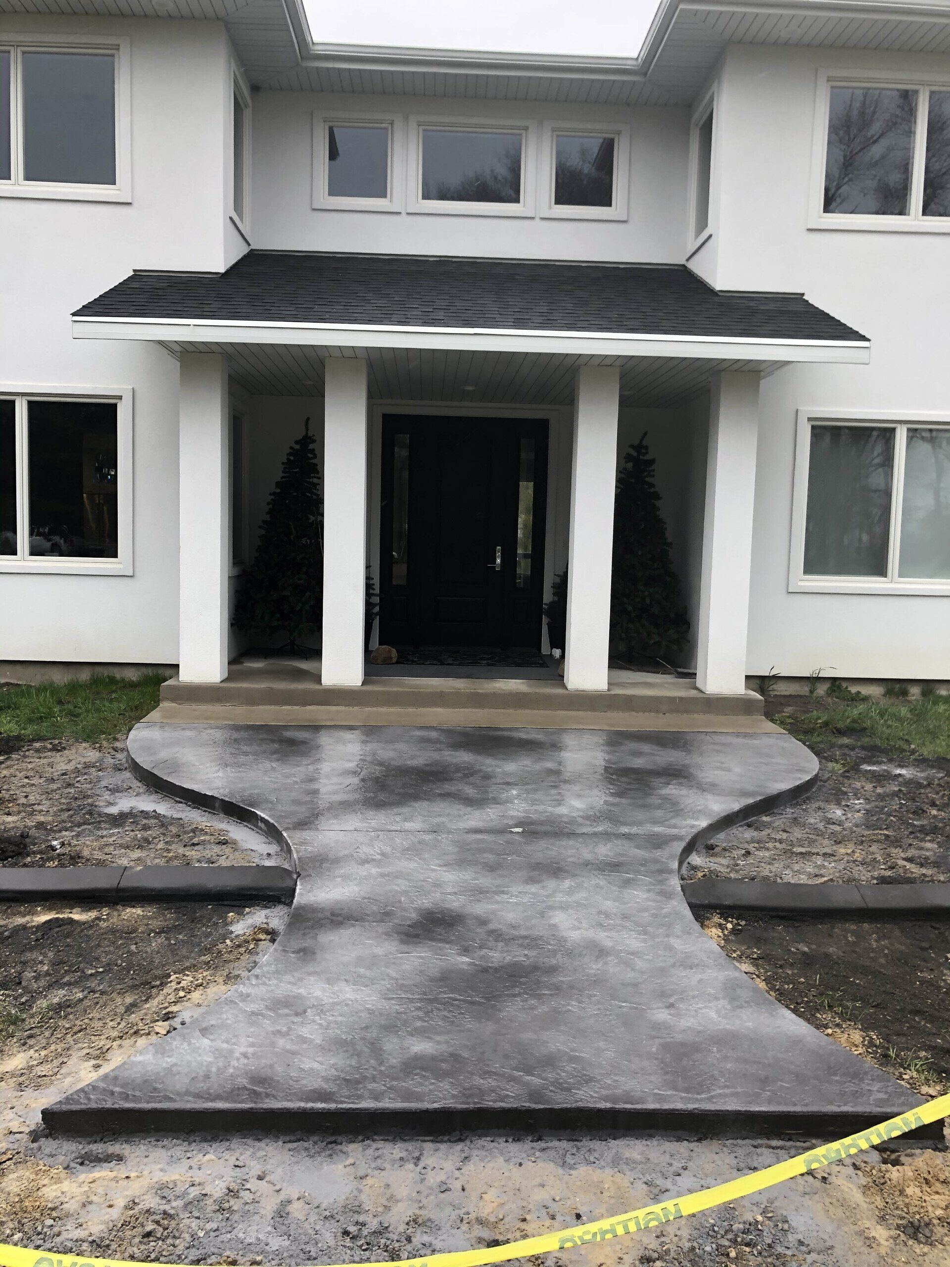 A brick house with a white garage door and a concrete driveway in front of it.