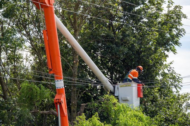 A man in a bucket is working on a power line.