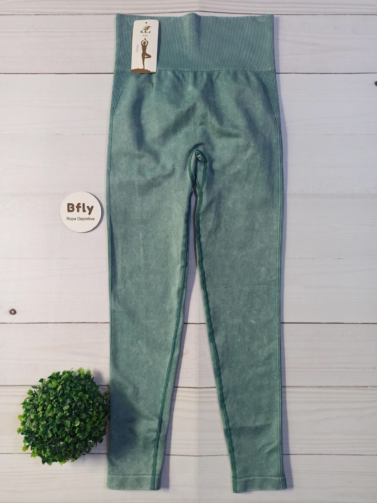Cuatro pares de pantalones deportivos ajustados en gris, azul, marrón y menta, extendidos sobre un fondo blanco.