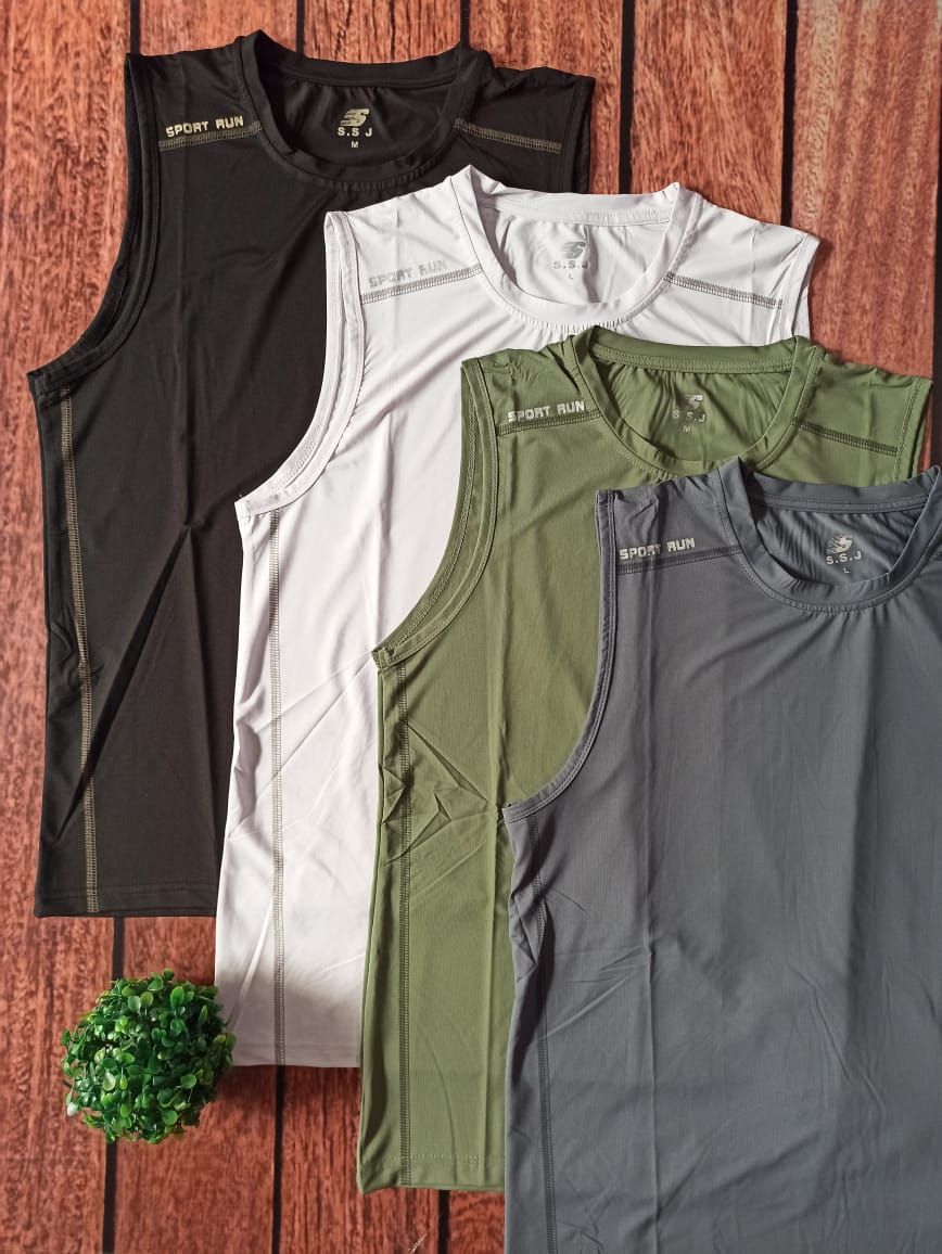 Una camiseta deportiva negra sin mangas extendida sobre una superficie de madera con una pequeña planta verde al lado.
