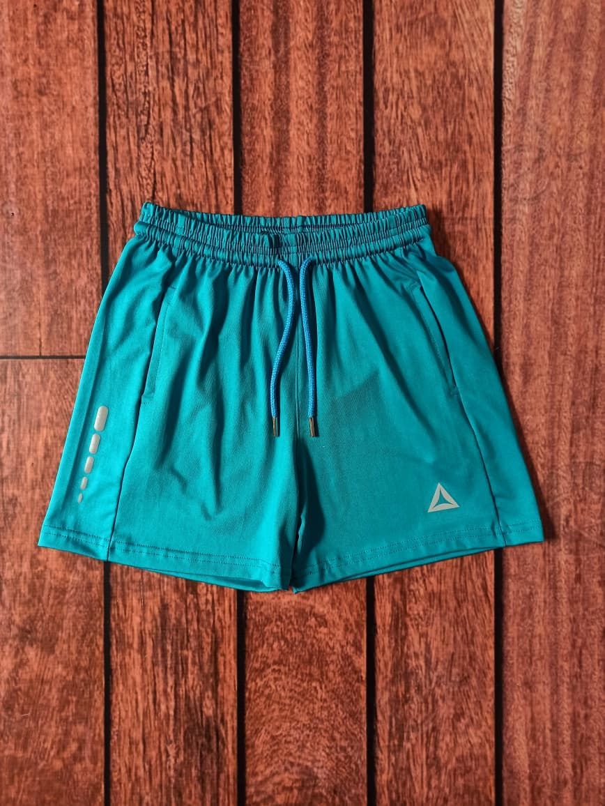 Pila de pantalones cortos deportivos de colores sobre una superficie de madera.