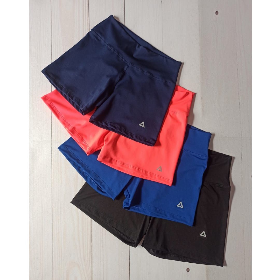 Mujer posando con ropa deportiva azul sobre un fondo blanco.