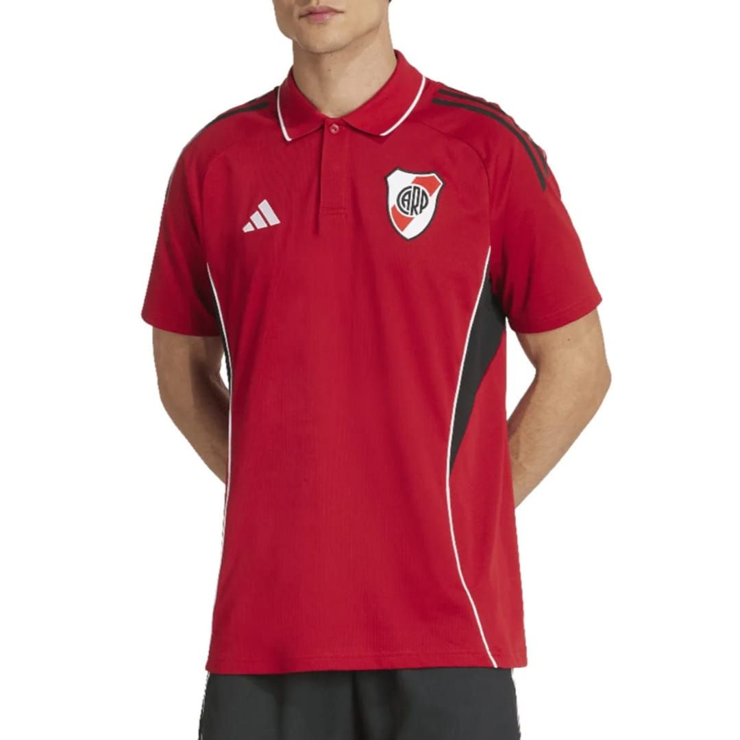 Polo Adidas de rayas rojas con el escudo del equipo en un maniquí masculino sobre un fondo blanco.