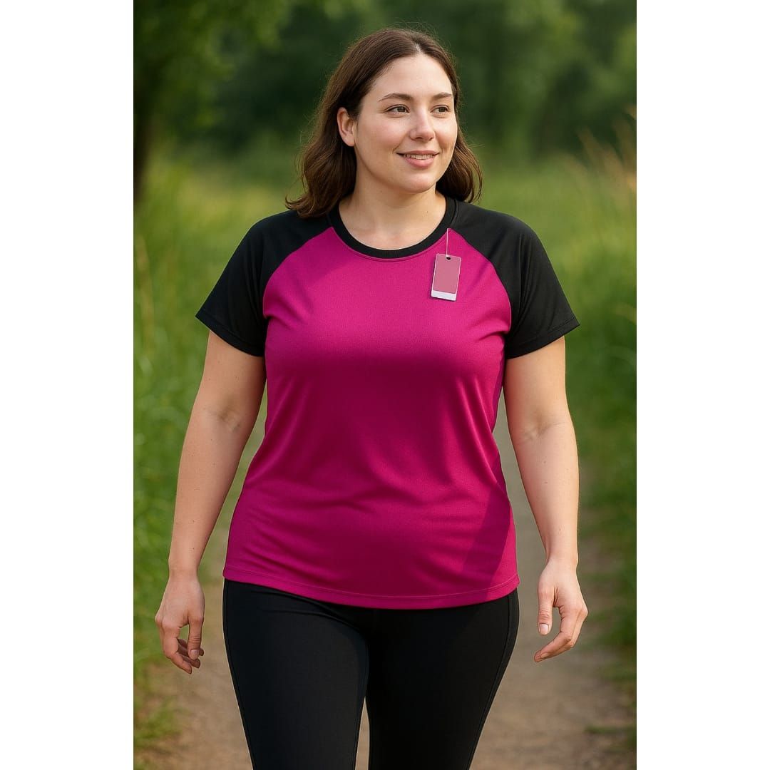 Persona con una camisa magenta y negra caminando por un sendero boscoso al aire libre.