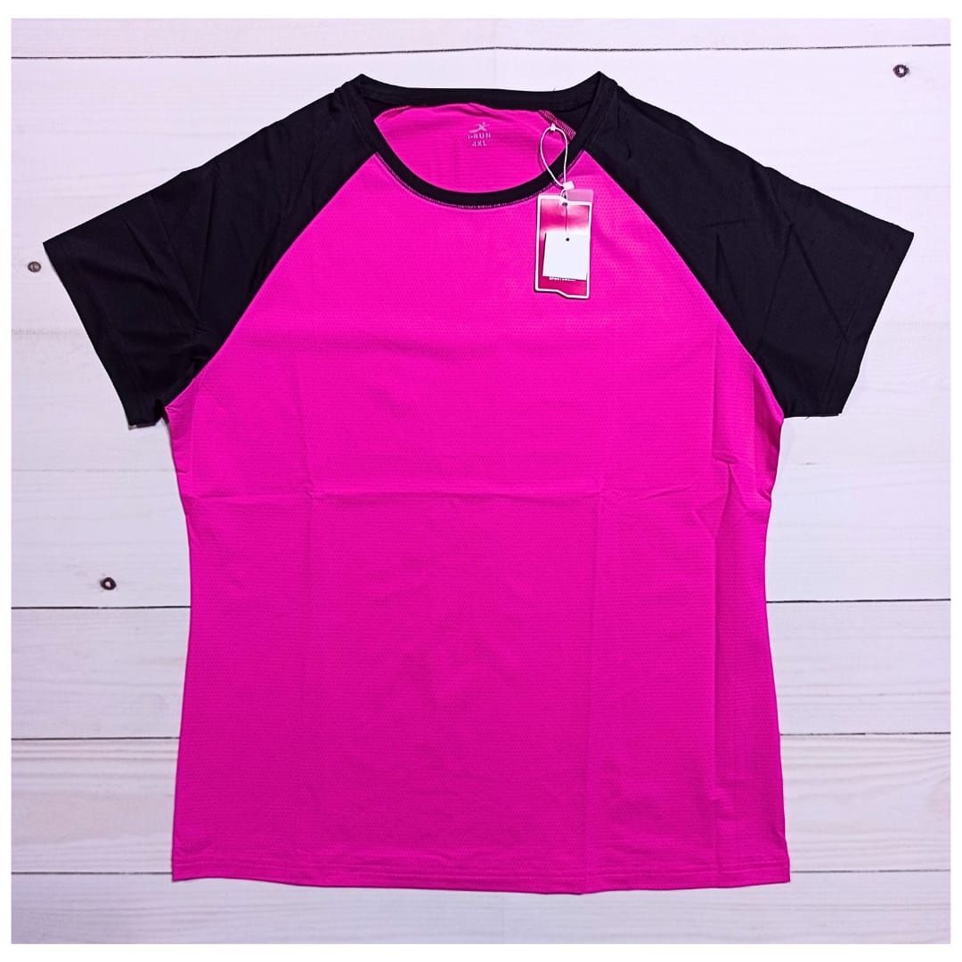 Persona con una camisa magenta y negra caminando por un sendero boscoso al aire libre.