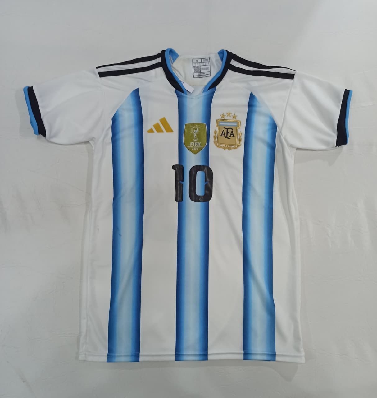 Camiseta de la selección argentina de fútbol, blanca con rayas azul celeste y número 10.