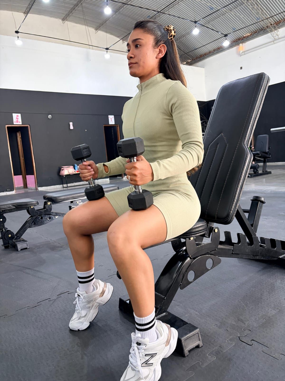 Mujer sentada en un banco de gimnasio