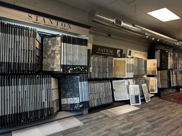Store showroom with wall-mounted tile displays and sample boards under fluorescent lighting
