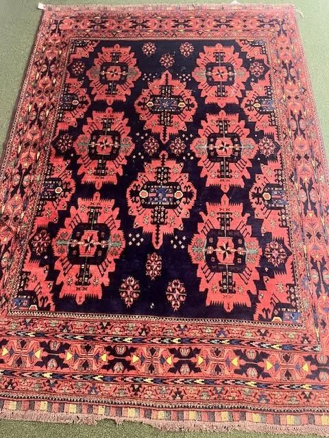 Patterned red and black woven rug with intricate floral and geometric designs