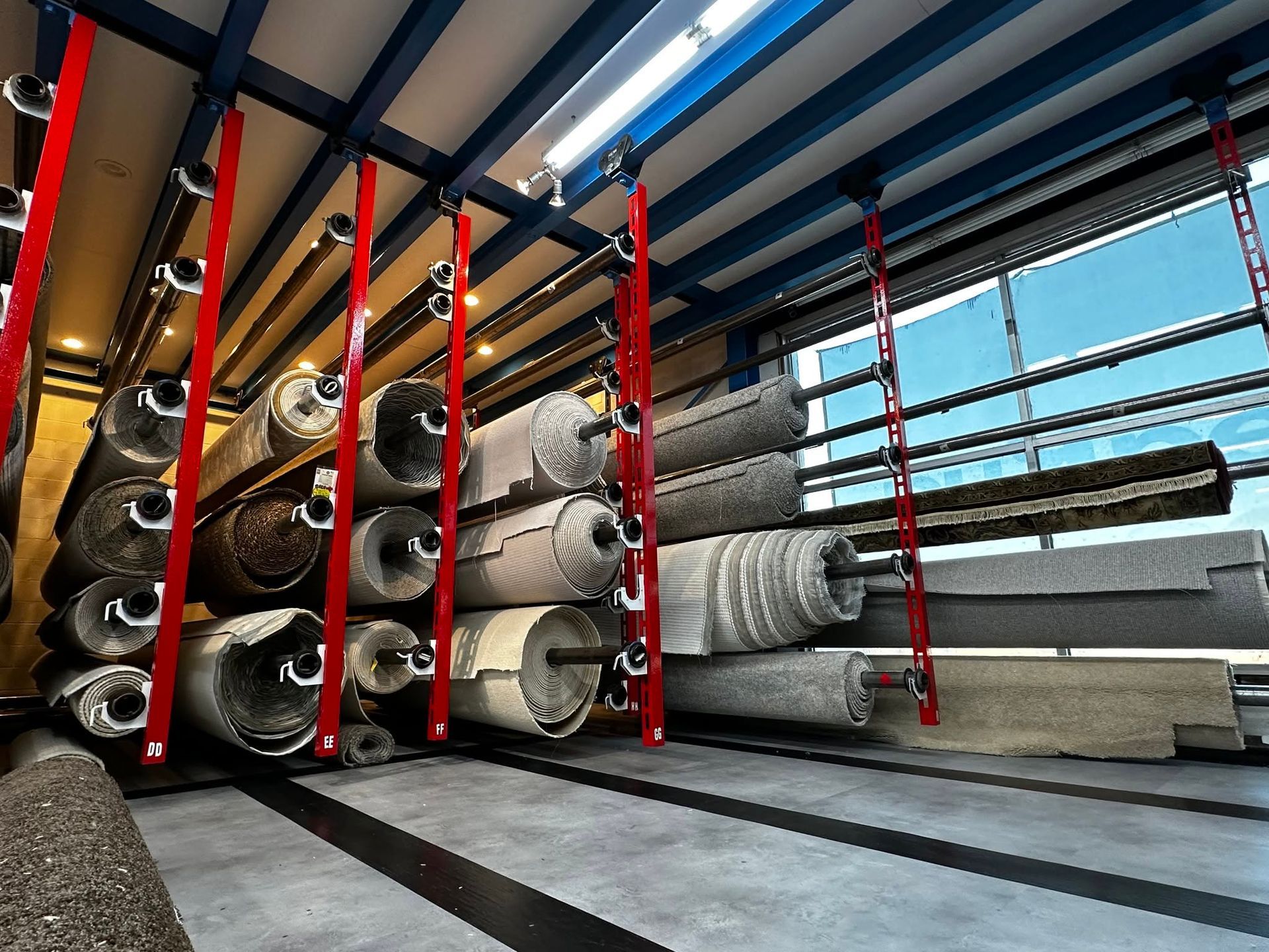 Industrial warehouse with stacked rolls of carpet or fabric on shelving units