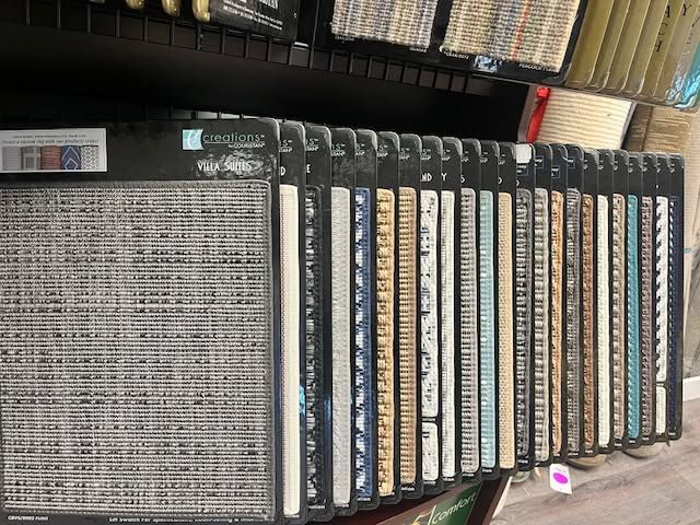 Books and DVDs arranged upright on a shelf, with a large open binder or album in front.