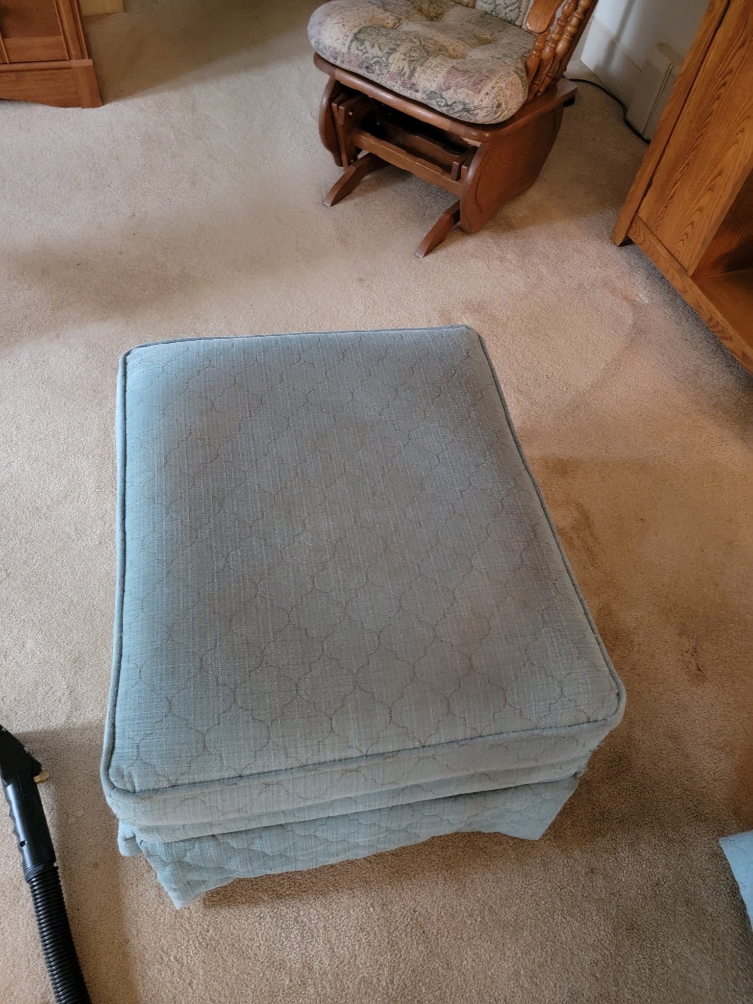Stack of light blue cushions on a beige carpet in a living room