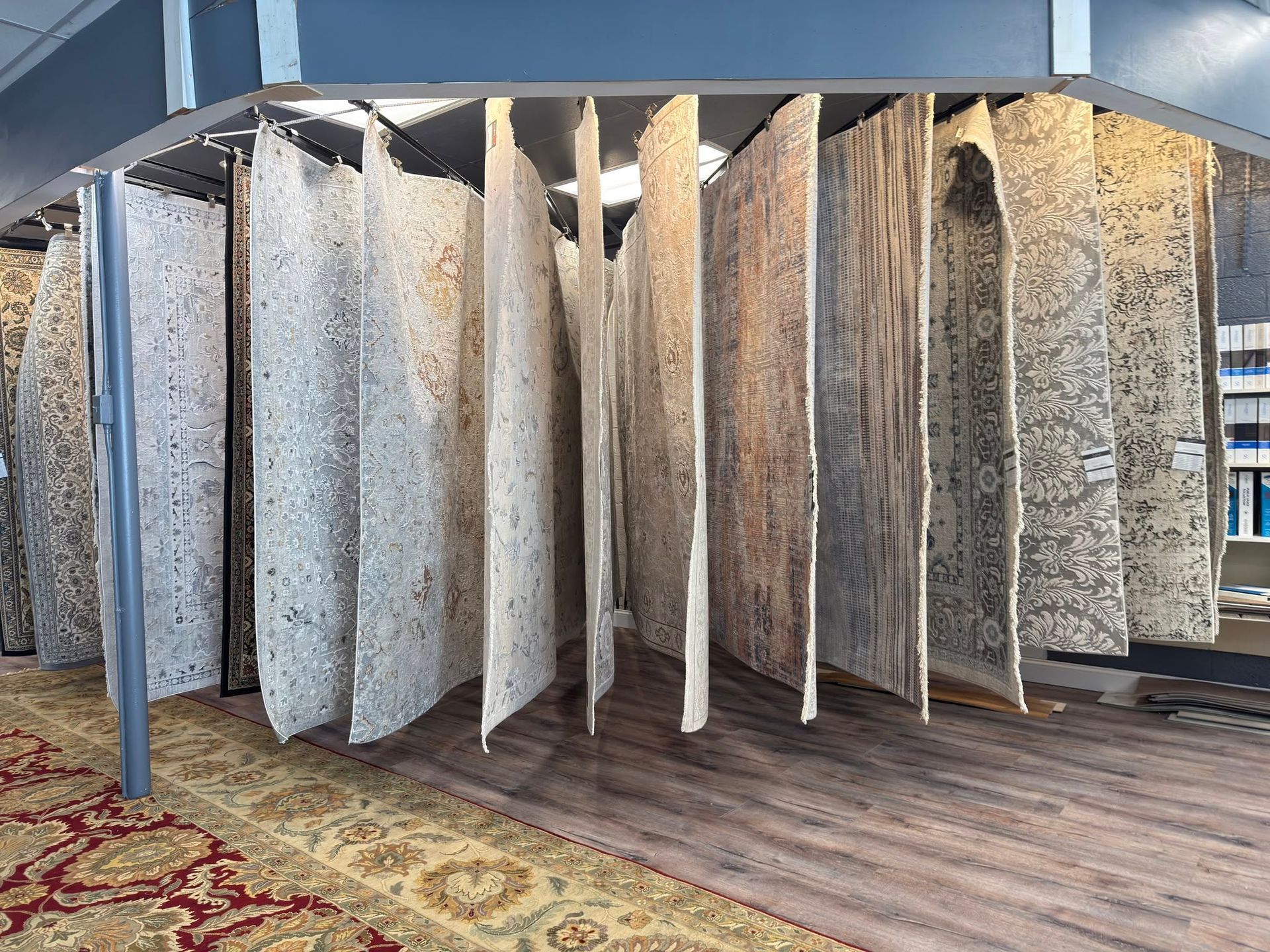 Large granite countertop slabs displayed upright on a showroom floor with wood-style flooring and a patterned rug.
