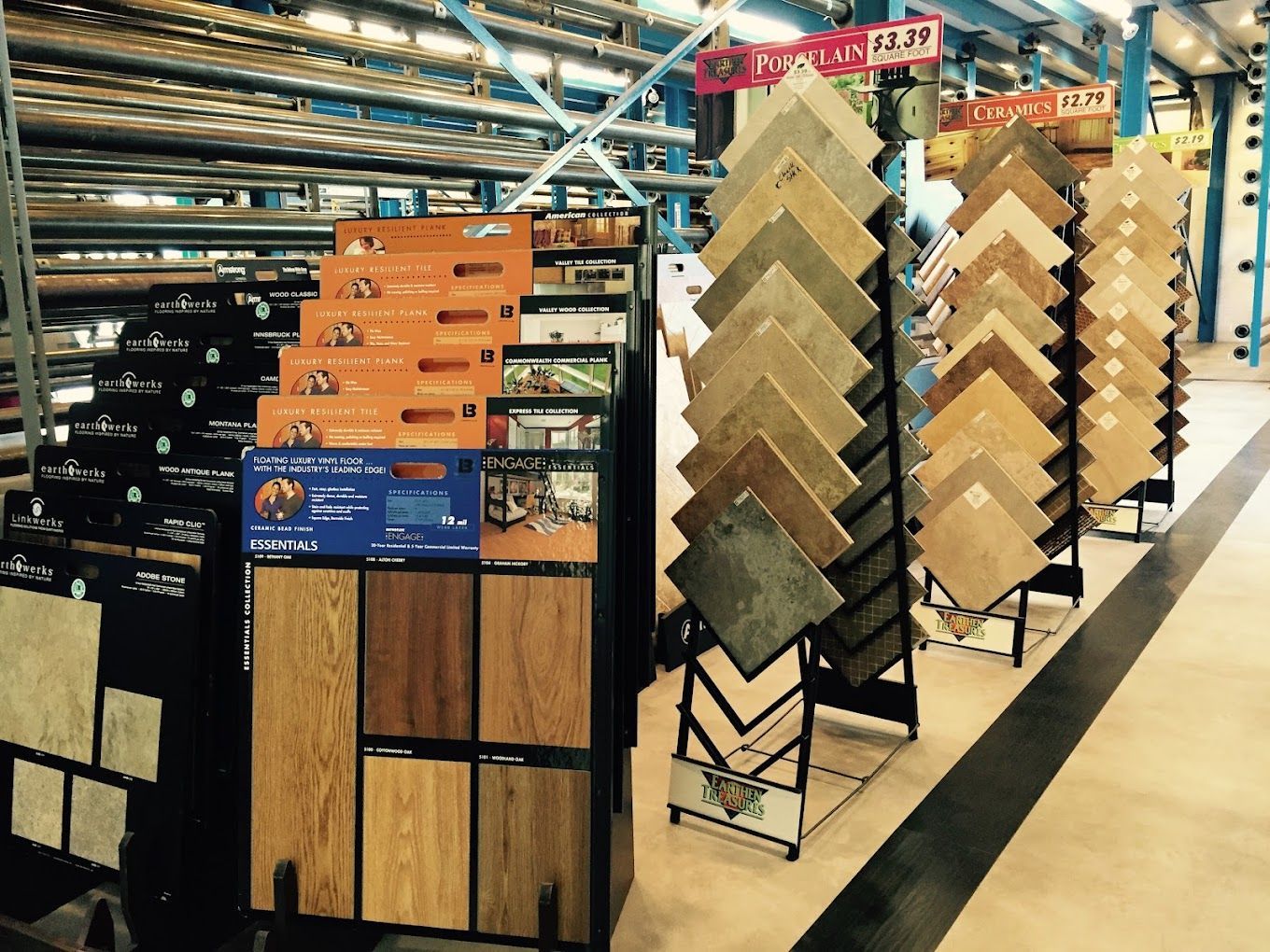 Flooring store aisle with wood-look tile sample displays and hanging signs