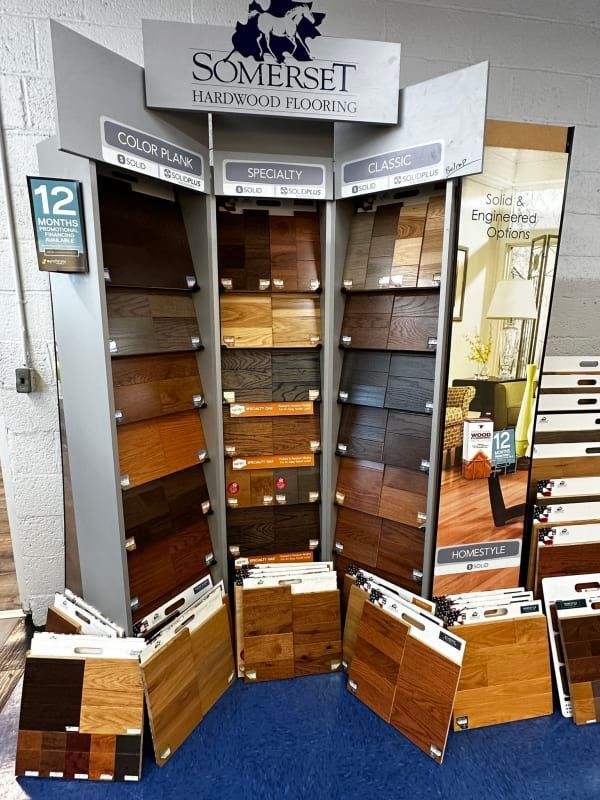 Corner display of Somerset flooring samples in a showroom, with wood plank drawers and signage.