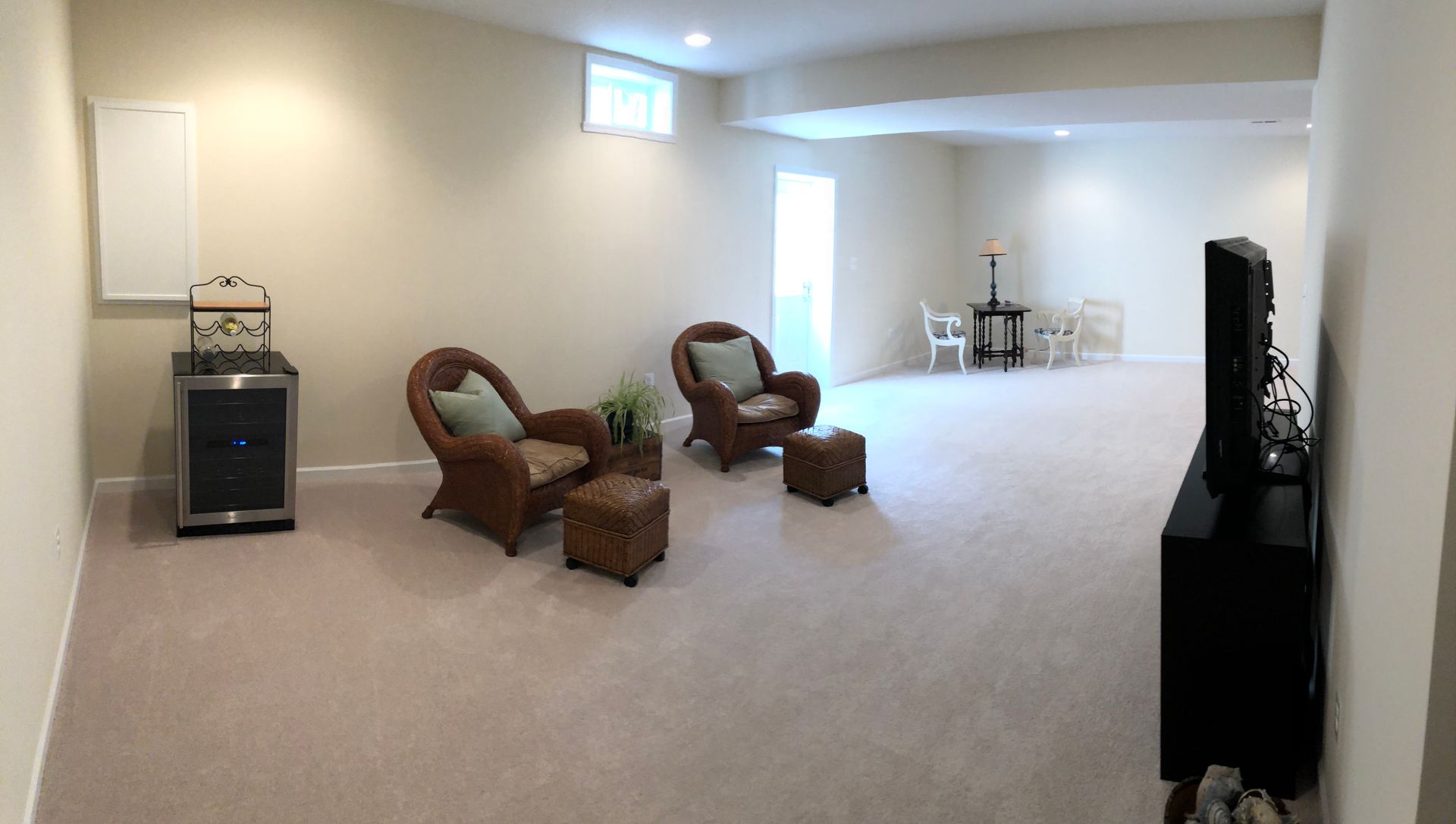 A living room with two chairs and a television.
