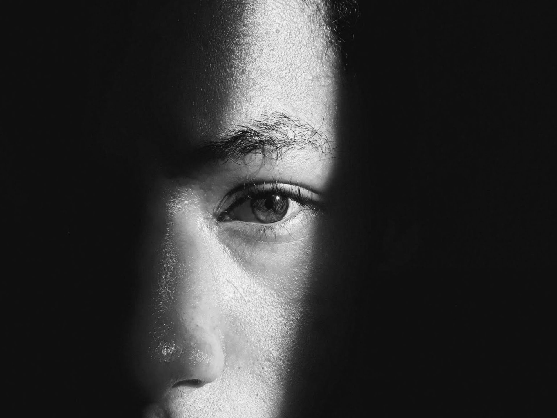 Black and White image of a human face in light and shadow