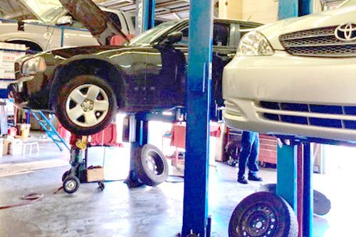 A car is sitting on a lift in a garage.