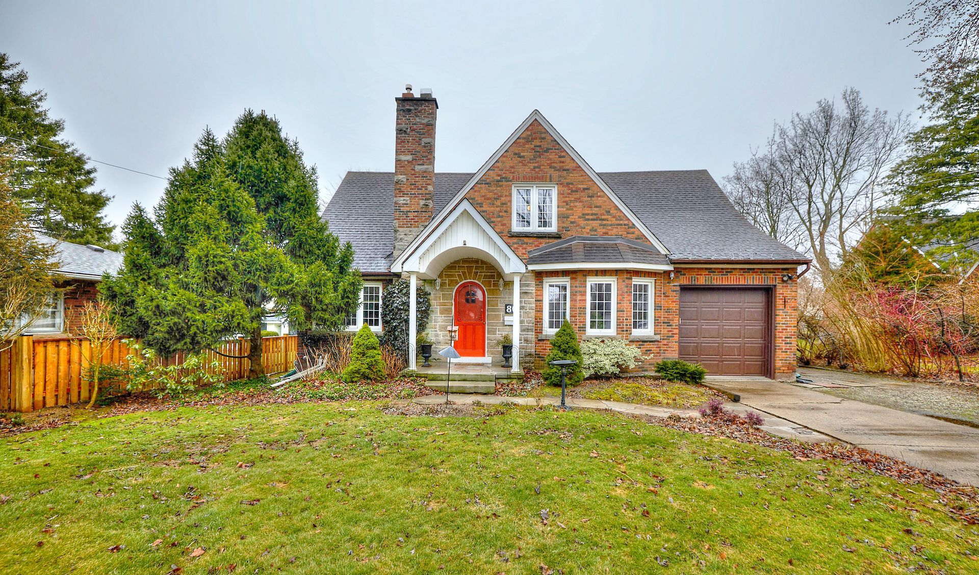 A serene and tranquil view of a residential property with a vibrant red front door.