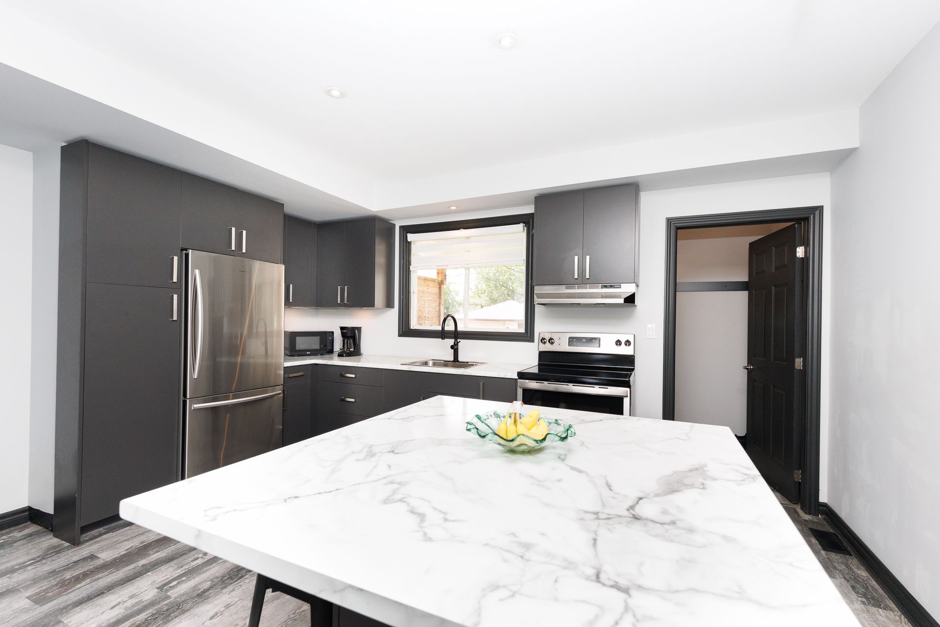 A modern black and white kitchen with a large centre island.