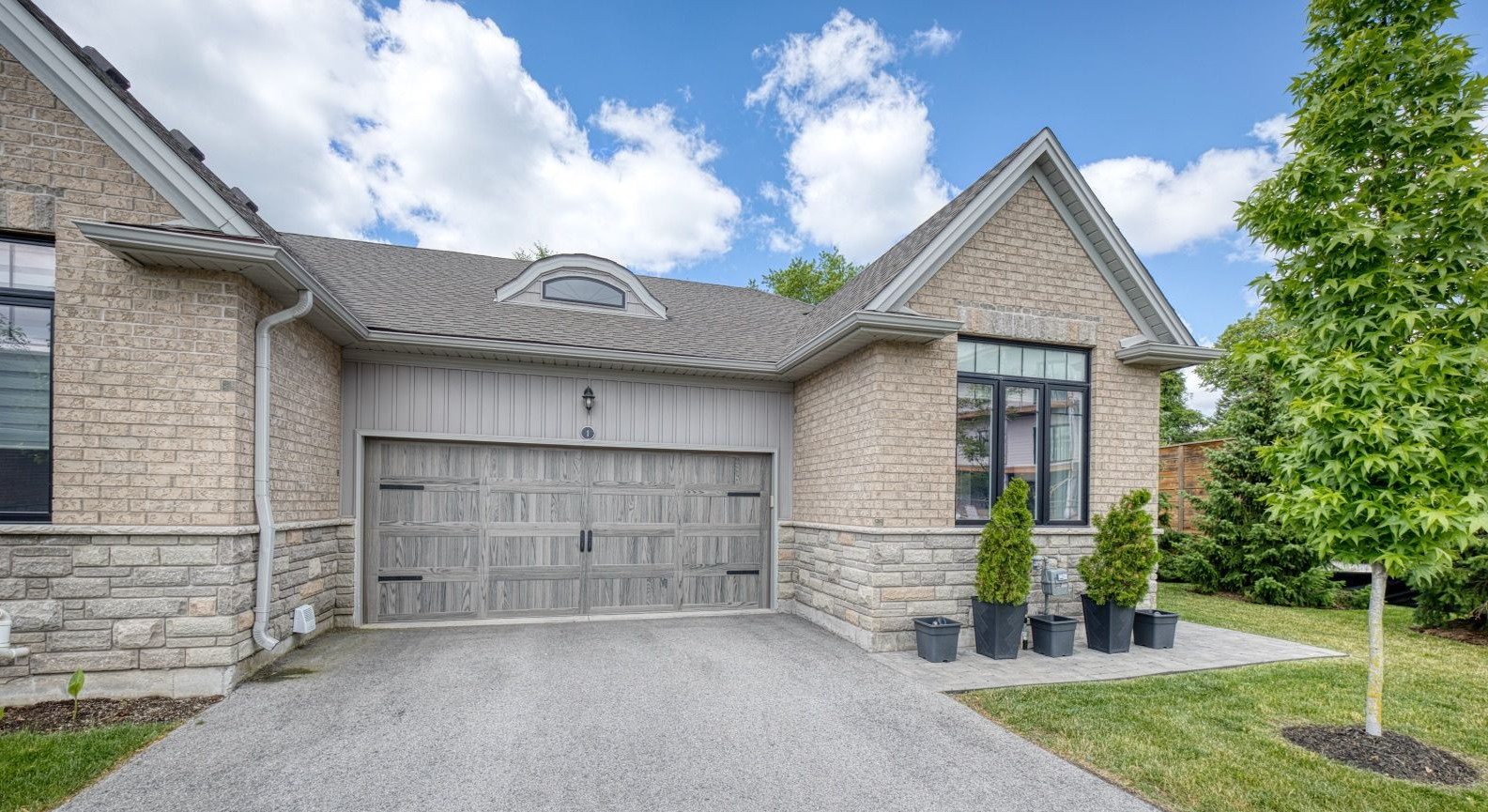A bungalow townhouse condo with an attached two-car garage.